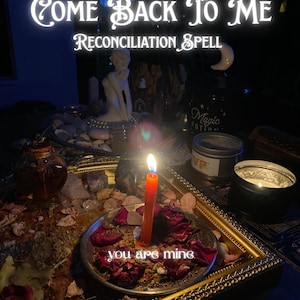 Puede incluir: Una vela naranja encendida sobre un plato plateado con pétalos de rosa y la frase "you are mine". El plato está sobre una bandeja con marco dorado con el texto "Come Back To Me Reconciliation Spell" en el fondo. Otros elementos incluyen velas y una estatua.