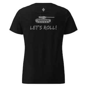 May include: Black t-shirt featuring a gray illustration of a tank and the phrase "LET'S ROLL!" in a stylized font. The design includes a diamond shape above the tank. The shirt is made of a soft material.