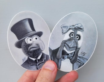 May include: Two black and white illustrated stickers of characters wearing formal attire. The character on the left is wearing a top hat and bow tie. The character on the right is wearing a bow tie and a large bow on their head.