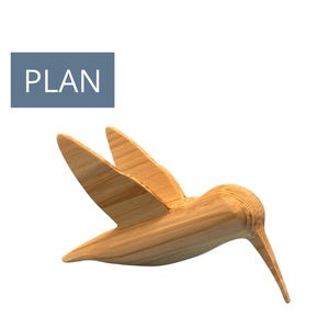 May include: A wooden hummingbird sculpture with outstretched wings and a long beak. The bird is made of light-colored wood and is angled downward. The word "PLAN" is in a blue rectangle in the upper left corner.