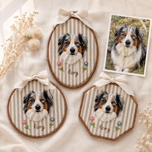 May include: Three custom needle-felted portraits of an Australian Shepherd dog named Remy, displayed in wooden embroidery hoops of oval, round, and octagonal shapes. Each hoop features beige and white striped fabric, a cream ribbon, and small flowers.