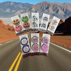 May include: A collection of car coasters with various designs and text. Some feature smiley faces, jack-o'-lanterns, and the text "Spooky Halloween Cookie!". Others have phrases like "But did you DIE?" and "Survivor".