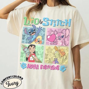 May include: Cream-coloured t-shirt with a vibrant Lilo & Stitch graphic. The design showcases Stitch on a skateboard, Angel with a heart, Lilo with a doll, and a character with a hat. Text reads "Lilo & Stitch" and "Aloha Everyone."