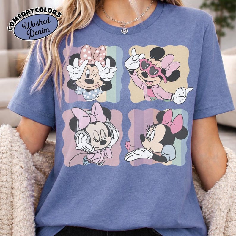 May include: Blue t-shirt with a graphic of Minnie Mouse in four different poses. The graphic is in a square format with pastel rainbow stripes. The shirt has the words "Comfort Colors" and "Washed Denim" in a circular logo.