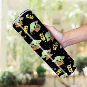 May include: A black, cylindrical tumbler with a repeating pattern of Grogu from Star Wars, and yellow Star Wars logos. The tumbler is likely made of stainless steel.
