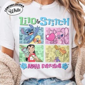 May include: White t-shirt with a vibrant graphic of Lilo & Stitch characters. The design showcases Stitch on a skateboard, Angel with a heart, Lilo with a doll, and another character. The words "Lilo & Stitch" and "Aloha Everyone" are also printed on the shirt.