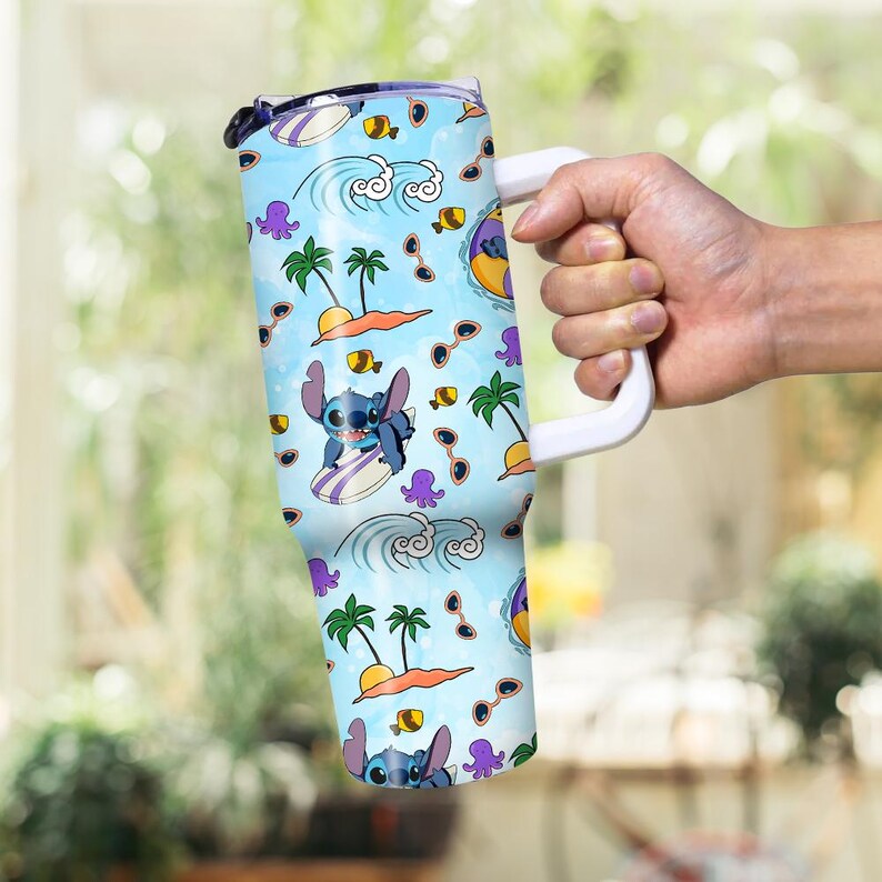 May include: A large, insulated tumbler with a white handle, featuring a light blue background with a repeating pattern of Stitch surfing, palm trees, sunglasses, and waves. The tumbler is designed to keep beverages cold or hot.