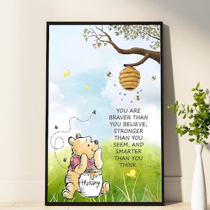 May include: A framed print featuring Winnie the Pooh with a honey pot, bees, and a beehive. The artwork includes the text "YOU ARE BRAVER THAN YOU BELIEVE, STRONGER THAN YOU SEEM, AND SMARTER THAN YOU THINK." The background is a green field and blue sky.