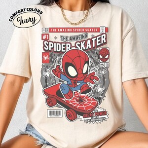 Puede incluir: Camiseta marfil Comfort Colors con un dise&ntilde;o de c&oacute;mic de Spider-Man en monopat&iacute;n. El dise&ntilde;o incluye el texto "THE AMAZING SPIDER SKATER" y "WITH GREAT POWER COMES GREAT RESPONSIBILITY".