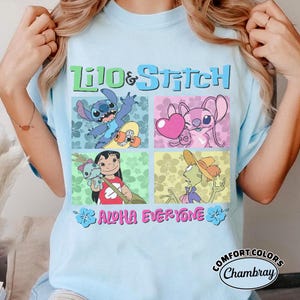 May include: Pale blue t-shirt with the words "Lilo & Stitch" and character illustrations in squares. The shirt also has the text "Aloha Everyone" and a Comfort Colors logo.