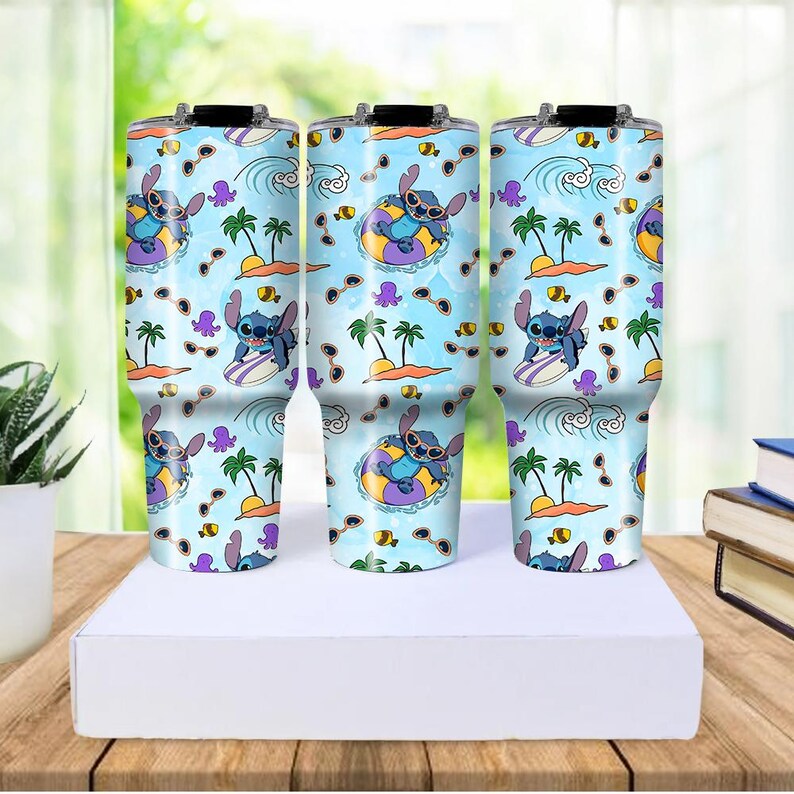 May include: Three stainless steel tumblers with a light blue background featuring a repeating pattern of Stitch from Lilo & Stitch. The design includes Stitch surfing, in a float, and palm trees. Each tumbler has a black lid.