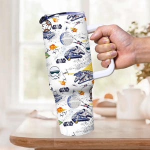 Op de afbeelding: Witte reismok met een grote witte handgreep, met een Star Wars-thema patroon. Het ontwerp bevat illustraties van de Millennium Falcon, X-wing fighters en de Death Star, met de woorden "Star Wars" herhaald.