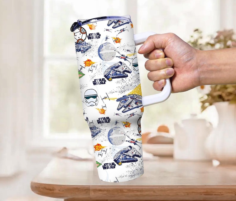 Op de afbeelding: Witte reismok met een grote witte handgreep, met een Star Wars-thema patroon. Het ontwerp bevat illustraties van de Millennium Falcon, X-wing fighters en de Death Star, met de woorden "Star Wars" herhaald.
