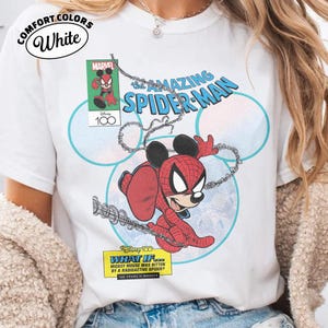 May include: White t-shirt featuring a comic-style illustration of Mickey Mouse as Spider-Man. The design includes the text "The Amazing Spider-Man" and "What If... Mickey Mouse was bitten by a radioactive spider?" with the Marvel and Disney 100 logos.