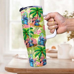 May include: A large, insulated tumbler featuring a colorful tropical design with palm trees, flowers, and cartoon characters. The tumbler has a white handle and a clear lid. The design includes images of Stitch and Lilo.