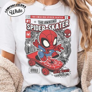 Puede incluir: Camiseta blanca con un dise&ntilde;o de c&oacute;mic de Spider-Man en monopat&iacute;n. El dise&ntilde;o incluye el texto "THE AMAZING SPIDER-SKATER" y "WITH GREAT POWER COMES GREAT RESPONSIBILITY". La camiseta est&aacute; etiquetada como "COMFORT COLORS".