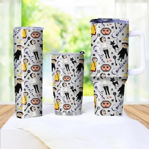 May include: Three stainless steel tumblers with a repeating pattern featuring characters and text from the movie "Coraline." The design includes a girl, a black cat, keys, and the text "Coraline" in a blue script. The tumblers are in different sizes.
