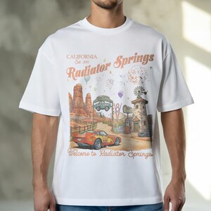 Puede incluir: Una taza de cer&aacute;mica blanca con un asa negra y el texto "But First, Coffee" en un estilo manuscrito. La taza est&aacute; sobre una superficie blanca. La taza mide aproximadamente 10 cm de alto.