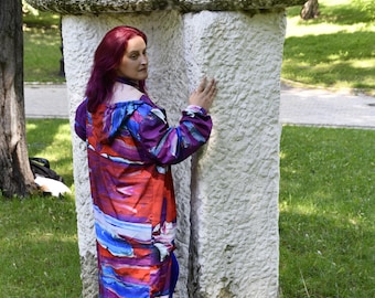 May include: A hooded long-sleeve jacket featuring a vibrant abstract print with horizontal bands of red, blue, purple, and white. The jacket has a full-length front zipper, a hood, and long sleeves with elastic cuffs, worn over solid blue leggings.