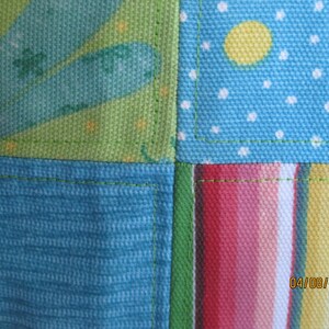 May include: Close-up of a patchwork fabric with a variety of patterns. The design includes sections of teal, green, and blue fabric with polka dots, stripes, and floral elements. The date "04/08/2012" is visible in the bottom right corner.