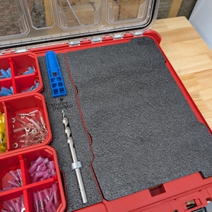 May include: A red tool case with clear lid compartments and red storage bins. Inside, a gray foam insert holds a drill bit, a blue tool, and various electrical connectors. The text "Misfire Designs" is visible.