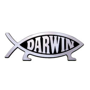 Op de afbeelding: Een zilverkleurig embleem in de vorm van een vis met een zwarte binnenachtergrond. Het woord DARWIN staat in dikke, witte hoofdletters in het midden van het vissenlichaam. Het ontwerp bevat twee kleine pootjes aan de onderkant en een staart links.