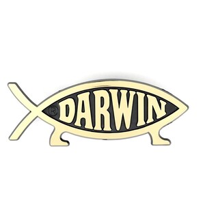Op de afbeelding: Een visvormig embleem met het woord DARWIN in dikke, lichtgekleurde letters tegen een zwarte achtergrond. Het ontwerp bevat een klein symbool voor een geregistreerd handelsmerk en twee korte pootjes aan de onderkant, als een lopende vis.