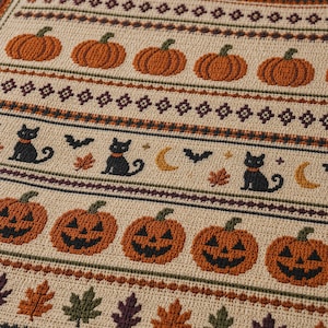 Peut inclure: Un textile tissé beige présentant des bandes horizontales de motifs saisonniers. Le motif comprend des rangées de citrouilles orange, de chats noirs, de croissants de lune, de chauves-souris et de feuilles d'automne aux tons vert, brun et violet.