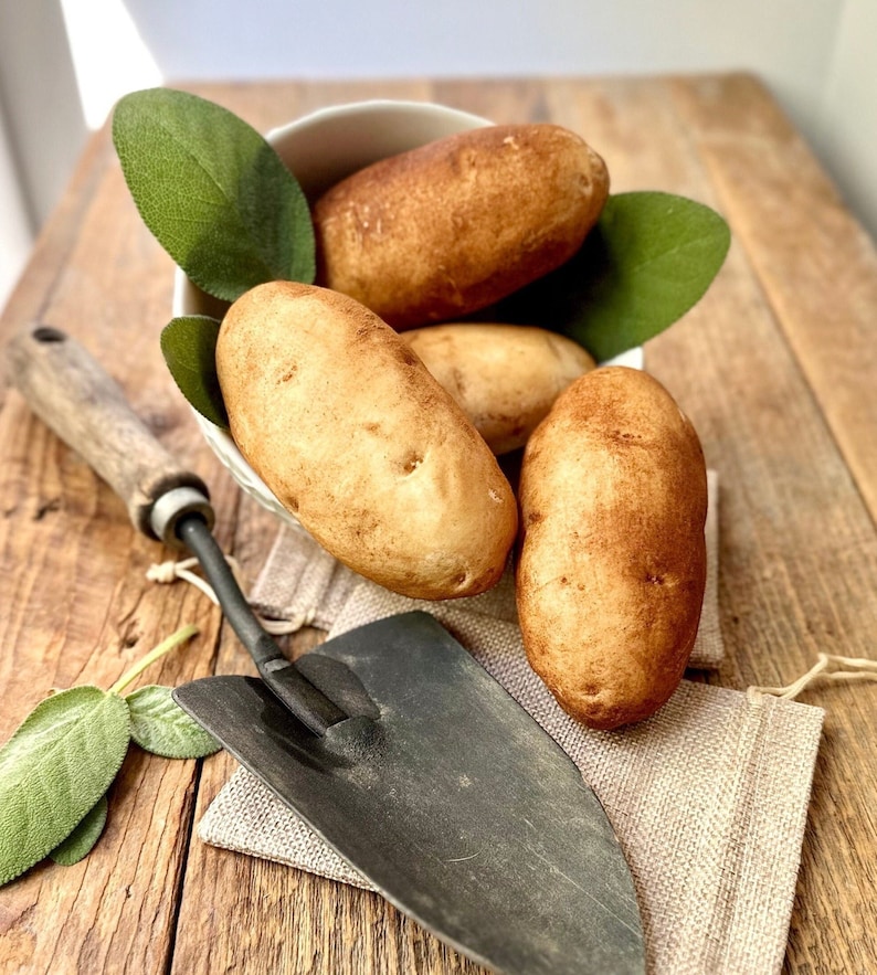 Four potato shaped soaps and a shovel