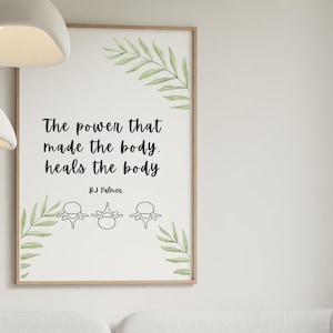 Op de afbeelding: Een ingelijste print met de quote "De kracht die het lichaam maakte, geneest het lichaam" in zwarte tekst. De print heeft een licht houten frame en groene bladaccenten. De print wordt weergegeven boven een witte bank in een woonkamer.