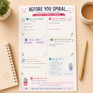 Può includere: Un foglio di lavoro in carta bianca intitolato BEFORE YOU SPIRAL... A gentle reset for overwhelming moments. Presenta sette sezioni numerate con suggerimenti per la riflessione, tra cui What Just Happened, What Am I Thinking e Help Me Reset.