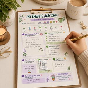 Puede incluir: Una hoja de trabajo impresa titulada My Brain Is Loud Today sobre un portapapeles de madera. El documento incluye secciones para el seguimiento del estado de &aacute;nimo, necesidades y consejos de autocuidado con ilustraciones florales. Un bol&iacute;grafo dorado descansa sobre el papel, que contiene notas manuscritas sobre tareas, pensamientos excesivos y pausas para respirar.