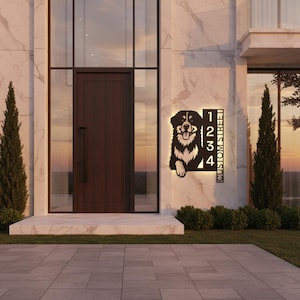 Peut inclure: Panneau de numéro de maison en métal noir avec une silhouette de chien, affichant les chiffres 1234 et le texte "CUSTOM STREET". Le panneau est monté sur un mur en marbre près d'une porte d'entrée.