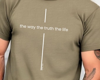 May include: Heather olive green t-shirt featuring a white cross design and the text "the way the truth the life". The shirt has short sleeves and a crew neck. The text "JOHN 14:6" is printed vertically on the cross.
