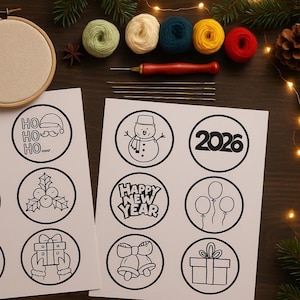Peut inclure: Une scène d'artisanat avec des cerceaux à broder, des boules de fil colorées et des outils. Des feuilles de papier blanc affichent des dessins au trait noirs d'images sur le thème des fêtes, dont un bonhomme de neige et le texte "Happy New Year."