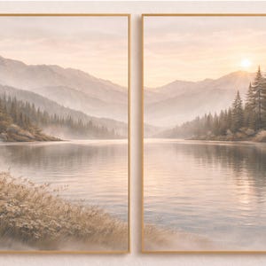 May include: A diptych wall art set featuring a landscape of a calm lake surrounded by pine trees and distant mountains under a soft sunrise sky. The scene is rendered in muted beige, brown, and pale pink tones, framed in thin light wood frames.