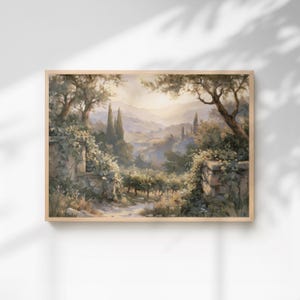 May include: A rectangular landscape painting in a light wood frame depicting a sunlit valley scene. The composition features stone walls covered in climbing vines in the foreground, framing a view of rolling hills, cypress trees, and olive groves.