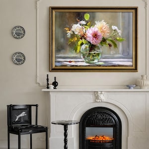 Op de afbeelding: Een ingelijst bloemstilleven met een gouden lijst, met een glazen vaas gevuld met roze, witte en gele bloemen. Het schilderij hangt boven een witte open haard met een zwarte vuurhaard. Decoratieve borden en een zwarte stoel zijn ook zichtbaar.