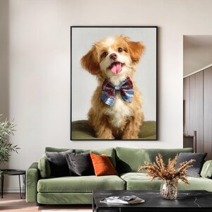 May include: A framed painting of a smiling, fluffy dog with brown and white fur. The dog wears a blue, red, and white plaid bow tie. The dog's tongue is visible. The painting is displayed above a green sofa.