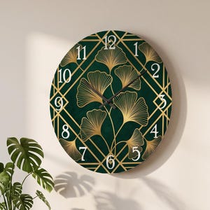 May include: A round wall clock featuring a deep green background with a gold geometric diamond pattern and gold ginkgo leaf illustrations. The clock face displays white numbers from 1 to 12 and includes two thin black hands for timekeeping.
