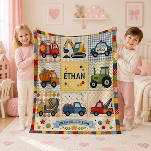 May include: A rectangular fleece blanket featuring a grid of nine squares with illustrations of a fire truck, excavator, police car, dump truck, tractor, cement mixer, pickup truck, and tow truck. The center square displays the name ETHAN.