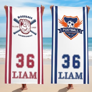 May include: Two white beach towels with sports designs. One has a baseball glove, bats, and text reading "Baseball Allstar League Tournament" with the number 36 and the name "Liam". The other towel features a football crest and the same number and name.