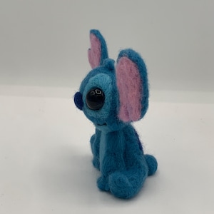 Puede incluir: Figura de Stitch de fieltro azul hecha a mano, con grandes ojos negros y orejas internas rosas. El peluche est&aacute; sentado, mostrando sus peque&ntilde;os brazos y piernas. El personaje de fieltro es popular de una pel&iacute;cula de animaci&oacute;n de Disney.