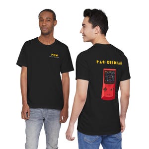 Könnte beinhalten: Schwarze T-Shirts. Eines hat gelben Text mit der Aufschrift "PHM PROJECT REAL MEAN". Das andere hat "PAC-ERIDIAN" in Gelb, mit einer roten Handheld-Spielkonsolen-Grafik. Die T-Shirts werden von zwei Personen getragen.