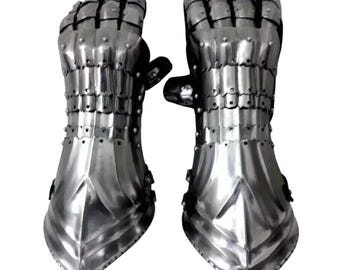 May include: A pair of polished steel gauntlets, featuring articulated fingers and a flared cuff design. The metal gloves are riveted together and appear to be medieval armor. The gauntlets are displayed against a white background.