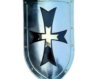 May include: A silver-colored shield with a black and gold cross design. The shield has a rounded bottom and is edged with rivets. The cross has four arrow-shaped arms, with a gold center.