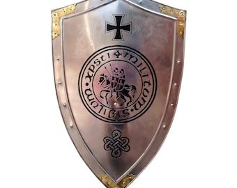 May include: A silver-colored shield with a black cross at the top and a circular emblem featuring a knight on horseback. The shield has gold-colored corner accents and a decorative knot design at the bottom.