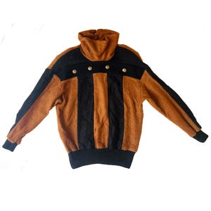May include: A vintage sweater with a high turtleneck collar. The sweater has a colour block design with black and brown panels, accented with gold buttons. The sleeves and cuffs are black, and the overall style is retro.
