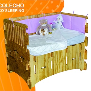 Puede incluir: Cuna de colecho de madera con protector rosa claro y colchón blanco. La cuna tiene un acabado de madera natural y se muestra en múltiples configuraciones, incluida una configuración de escritorio. El texto "COLECHO CO-SLEEPING" es visible.