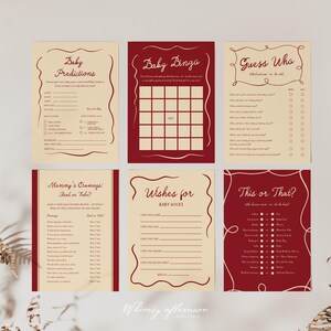 May include: Six baby shower game cards in burgundy and cream. The cards include games like "Baby Bingo" and "Guess Who?" with decorative borders and fill-in sections. The overall design has a vintage feel, perfect for a baby shower.